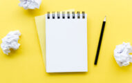 Top view of desktop with notebook and crinkled paper